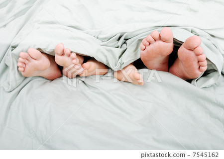 Happy familiy in bed under sheet 7545162