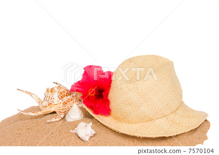 straw hat ans seashells on sand 7570104