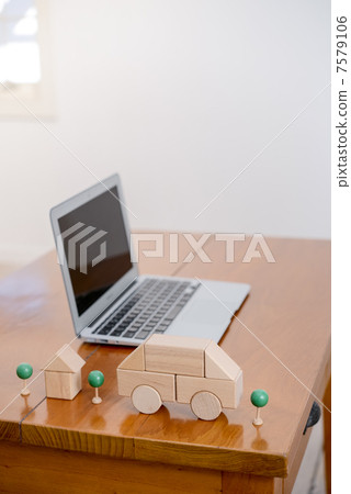 一張桌子上擺放著積木、汽車、房子和一台筆記型電腦。 一張桌子上擺放著積木、汽車、房子和一台筆記型電腦。 7579106