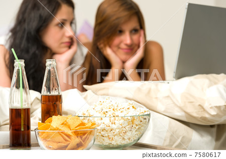 Young girls having slumber party, watching movies Young girls having slumber party, watching movies 7580617