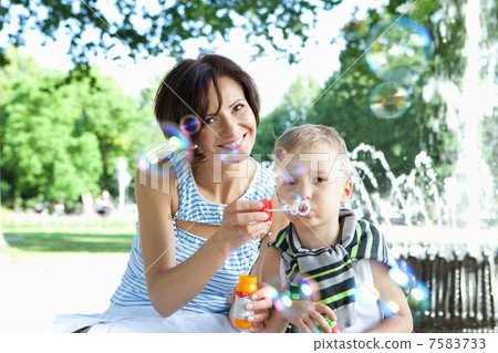 Happy mother and little son with soap bubbles outdoors Happy mother and little son with soap bubbles outdoors 7583733