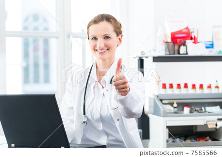 Female doctor writing on Pc in her clinic 7585566