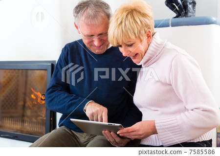 Seniors at home in front of fireplace Seniors at home in front of fireplace 7585586