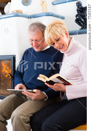 Seniors at home in front of fireplace Seniors at home in front of fireplace 7585587