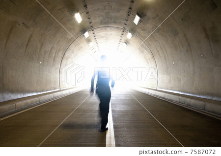 A businessman walking a tunnel 7587072