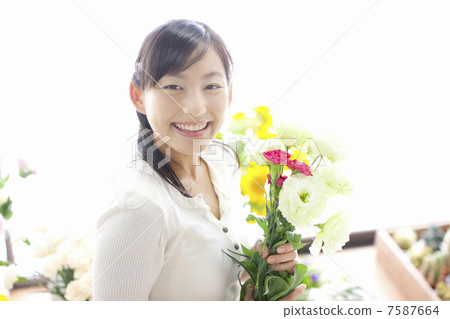 有拿著玫瑰的微笑的一名婦女 7587664