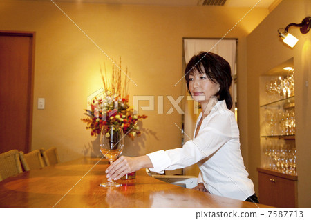 一個侍酒師女人給出一個酒杯 7587713
