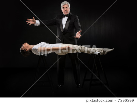 Portrait of professional hypnotist on black background working w Portrait of professional hypnotist on black background working w 7590599