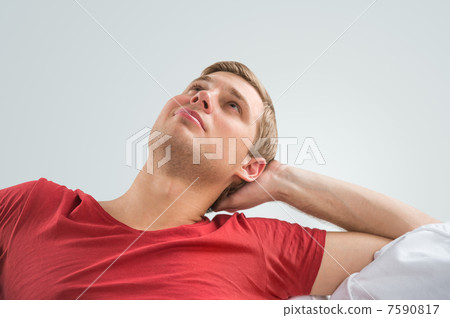 Portrait of a handsome young man looking upwards while relaxing Portrait of a handsome young man looking upwards while relaxing 7590817