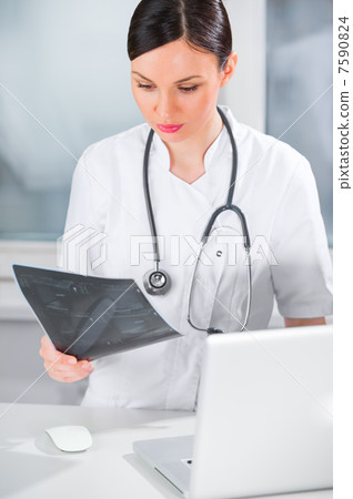 Portrait of a female doctor holding ultrasound results and using Portrait of a female doctor holding ultrasound results and using 7590824