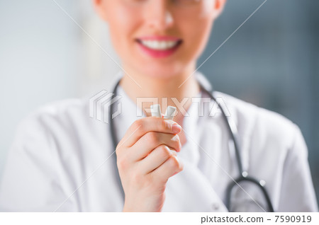 Young female dentist doctor holding chewing gum and smiling. Ora Young female dentist doctor holding chewing gum and smiling. Ora 7590919