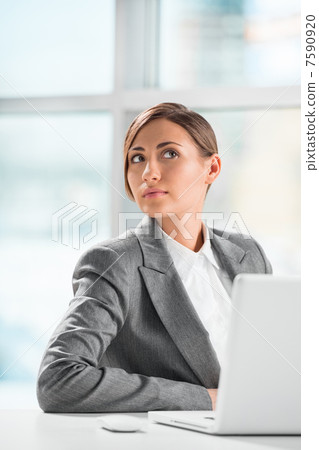 Portrait of business woman resting chin on hand in front of her Portrait of business woman resting chin on hand in front of her 7590920