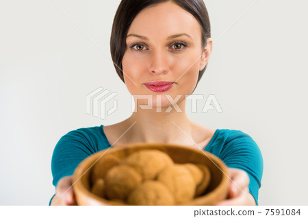 Beautiful woman holding hot fresh smelling oat cookies and smili Beautiful woman holding hot fresh smelling oat cookies and smili 7591084