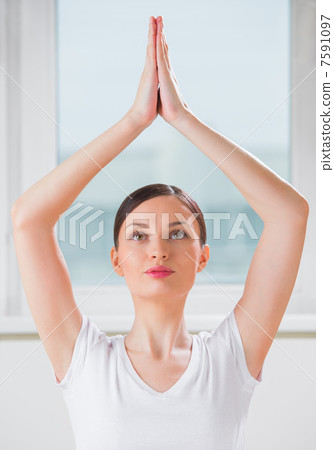 Portrait of a young beauty performing the yoga sitting tree posi Portrait of a young beauty performing the yoga sitting tree posi 7591097