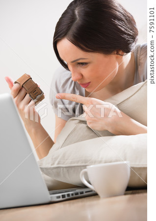 A young woman lying on the floor in front of her laptop and chat A young woman lying on the floor in front of her laptop and chat 7591101