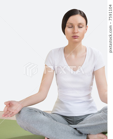 Portrait of pretty young woman doing yoga exercise on mat Portrait of pretty young woman doing yoga exercise on mat 7591104