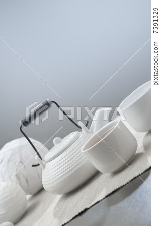 Teapot and cups on table at comfortable relaxation lounge Teapot and cups on table at comfortable relaxation lounge 7591329