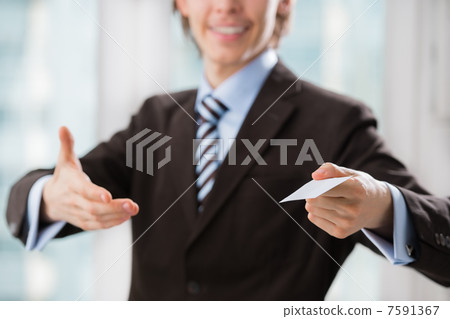 Business man holding a blank business card indoors at his office Business man holding a blank business card indoors at his office 7591367