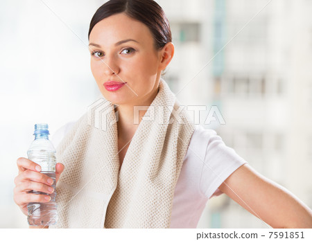 Portrait of confident young woman in sportswear holding a water Portrait of confident young woman in sportswear holding a water 7591851