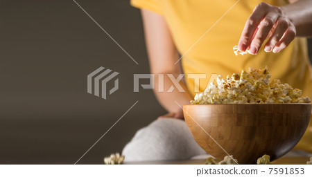 Unrecognizable woman eating popcorn at the cinema 7591853