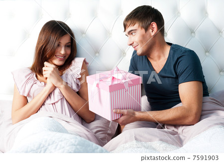 Closeup portrait of a happy young couple relaxing on the bed. Ma 7591903