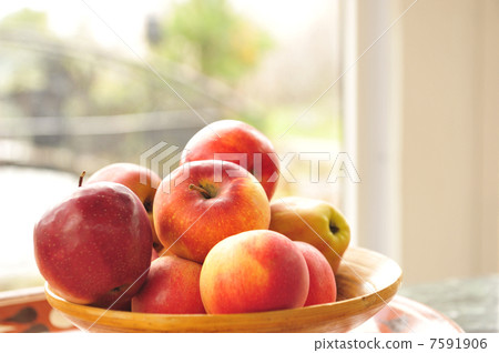 Closeup photo of red apples on wooden plate indoor against wide Closeup photo of red apples on wooden plate indoor against wide 7591906