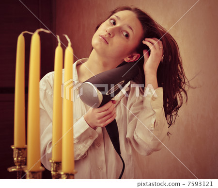 Beautiful woman drying her hair with hairdryer 7593121