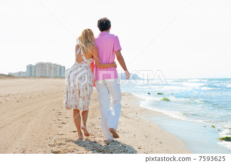 Couple at the beach holding hands and walking. Sunny day, bright Couple at the beach holding hands and walking. Sunny day, bright 7593625