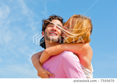 An attractive couple fooling around on the beach 7593670