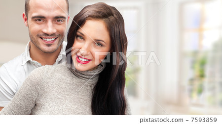 Portrait of young couple standing together at their home. Mortga 7593859