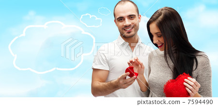 Happy young man gifting a ring to a beautiful surprised young wo 7594490
