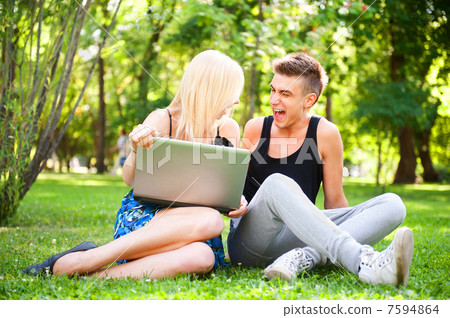 Young happy smiling couple with laptop at picnic Young happy smiling couple with laptop at picnic 7594864