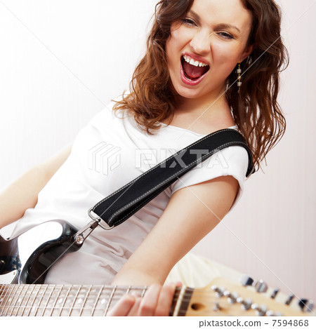 Portrait of beautiful young and attractive womanplaying her guit Portrait of beautiful young and attractive womanplaying her guit 7594868