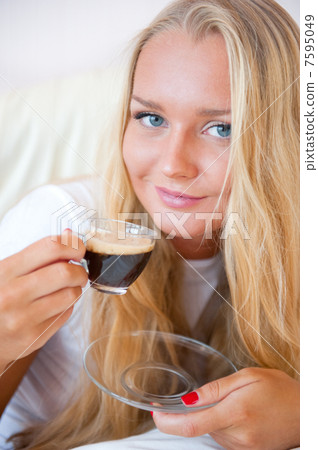 Closeup portrait of a pretty young female having a cup of coffee 7595049
