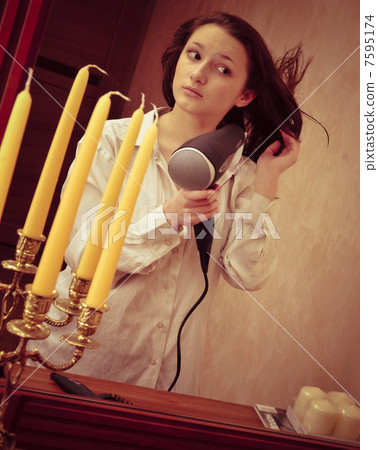 Beautiful woman drying her hair with hairdryer Beautiful woman drying her hair with hairdryer 7595174