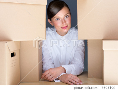 Portrait of young woman surrounded by lots of boxes. Lots of wor 7595190