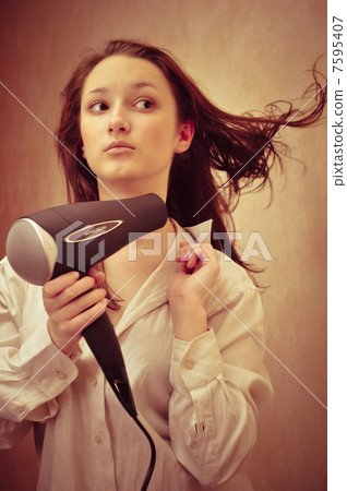 Beautiful woman drying her hair with hairdryer Beautiful woman drying her hair with hairdryer 7595407