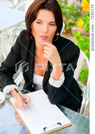 Business woman working with documents while having lunch or brea Business woman working with documents while having lunch or brea 7595575