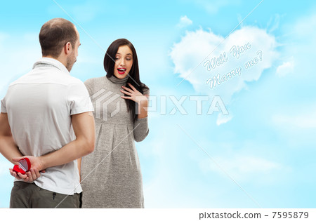 Happy young man gifting a ring to a beautiful surprised young wo Happy young man gifting a ring to a beautiful surprised young wo 7595879