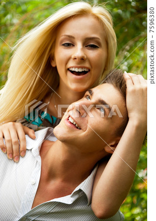 Portrait of love couple embracing outdoor in park looking happy 7596380