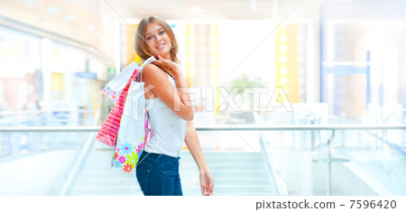 Happy shopping woman at the mall preparing gifts for her friends Happy shopping woman at the mall preparing gifts for her friends 7596420