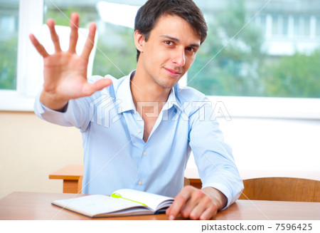 Businessman sitting indoors and writing plan in his diary 7596425