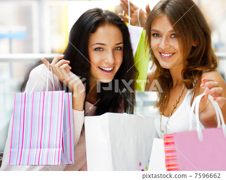 Two excited shopping woman resting on bench at shopping mall loo Two excited shopping woman resting on bench at shopping mall loo 7596662