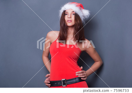 20-25 years od beautiful woman in christmas dress posing against 7596733
