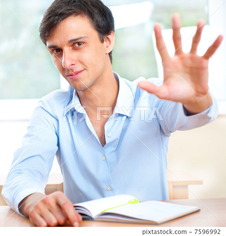 Businessman sitting indoors and writing plan in his diary 7596992