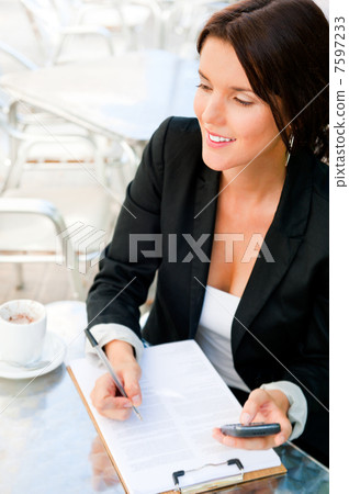 Business woman working with documents while having lunch or brea Business woman working with documents while having lunch or brea 7597233