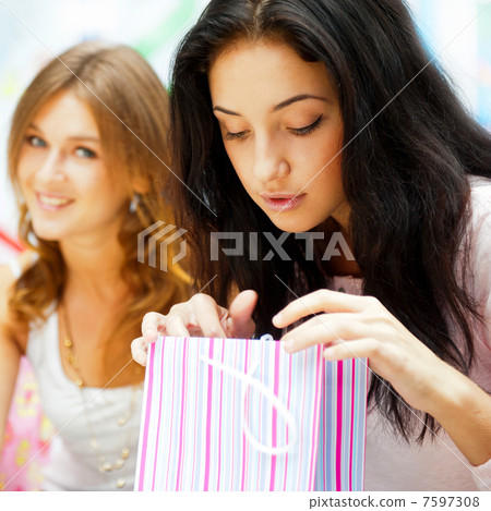 Two excited shopping woman resting on bench at shopping mall. Lo 7597308