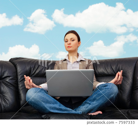 Portrait of young business woman sitting with a laptop on comfor 7597333