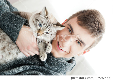 Relaxed man sitting on armchair holding and petting pet cat 7597365