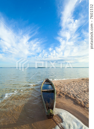 Old flooding boat on summer lake shore Old flooding boat on summer lake shore 7601532